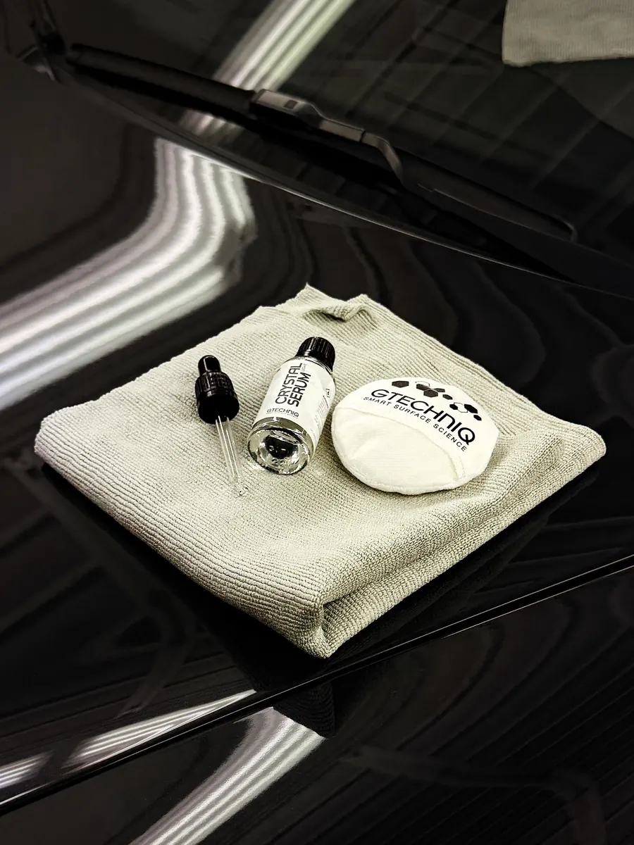 Flacon Gtechniq Crystal Serum, applicateur et microfibre posés sur un capot noir