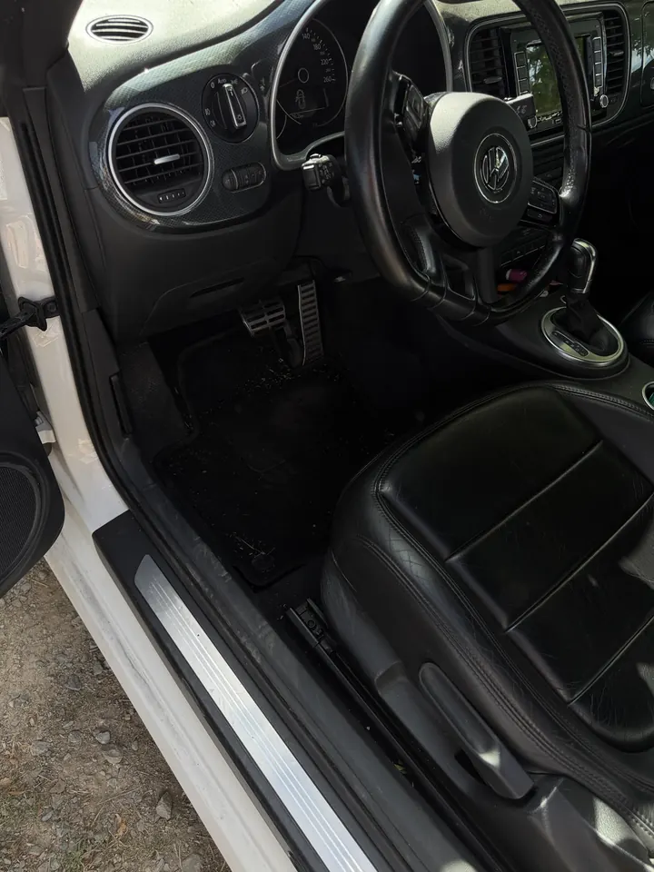 Poste de conduite d'une Volkswagen Beetle avant nettoyage intérieur, tapis sale